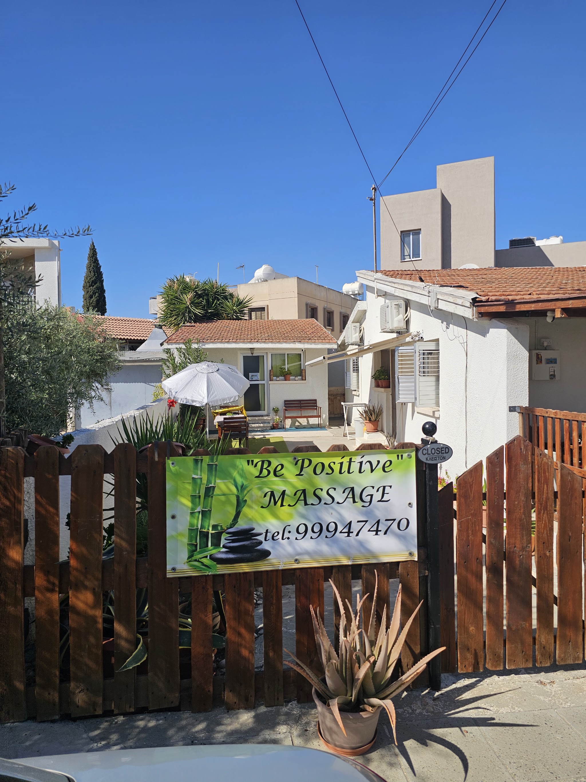 The painted Be Positive Massage sign at the entrance