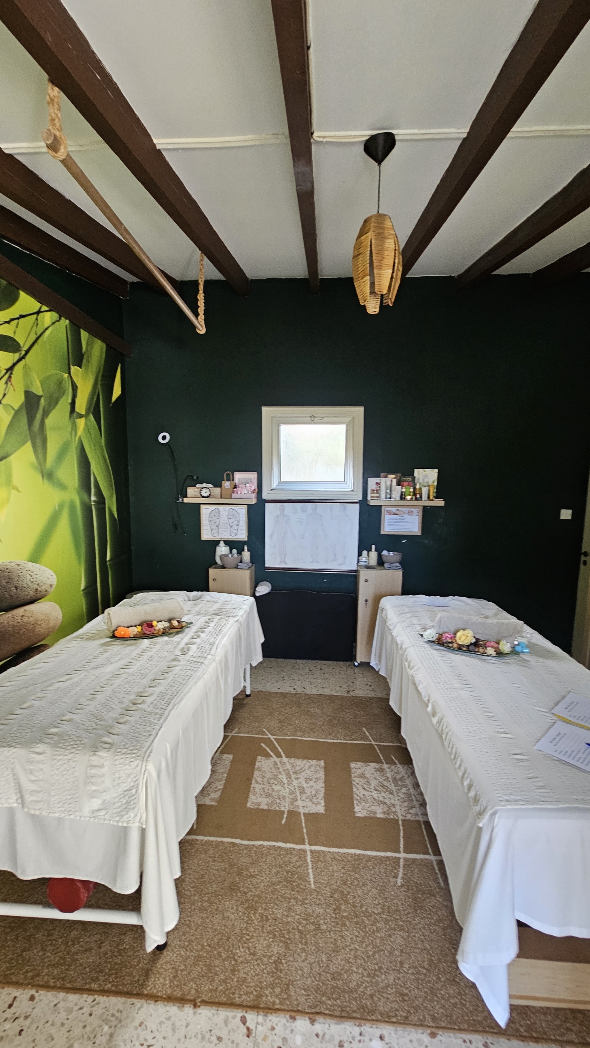 The couples treatment room, two beds dressed in white under a bamboo mural